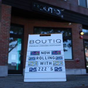 Daytime view of a sandwich sign outside our Maverick Square Dispensary, steps away from the Blue Line.